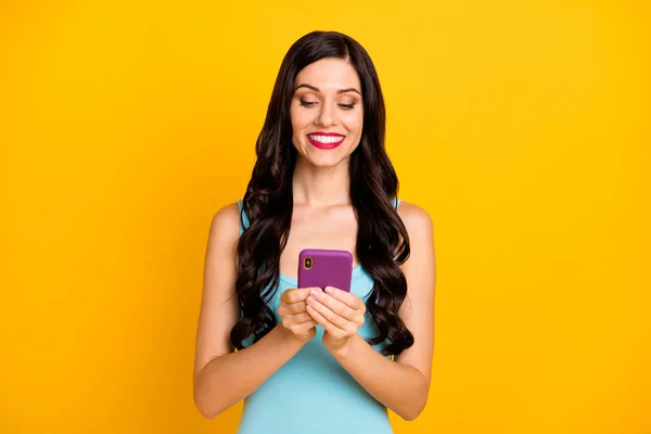 Foto de menina bonita segurar telefone olhar tela desgaste azul top isolado cor amarela fundo — Fotografia de Stock