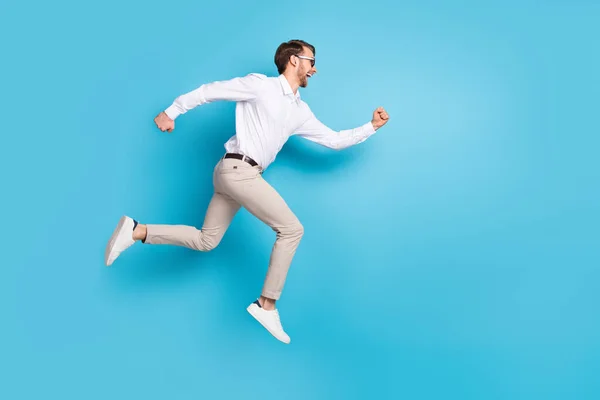 Full storlek profil sida foto av glad förvånad ung man springa hoppa upp tomt utrymme försäljning isolerad på blå färg bakgrund — Stockfoto