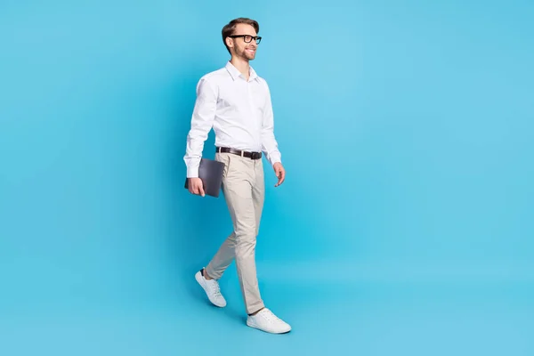 Volledige lichaamsomvang uitzicht van aantrekkelijke vrolijke man baas gaan dragen laptop geïsoleerd over helder blauw kleur achtergrond — Stockfoto