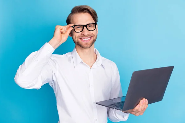 Porträtt av attraktiv glad man håller i händerna laptop vidröra specifikationer isolerade över ljusblå färg bakgrund — Stockfoto