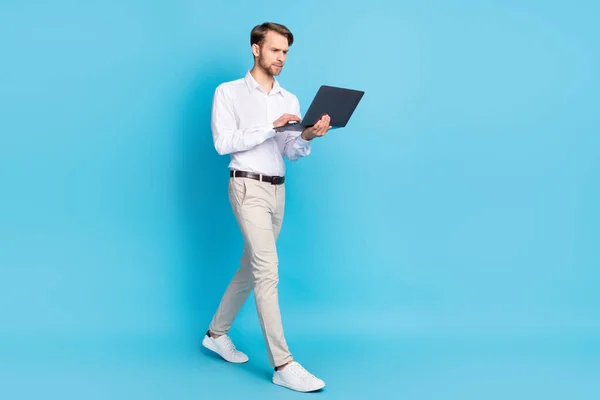 Pleine longueur vue de la taille du corps de l'homme attrayant en utilisant un ordinateur portable isolé sur fond de couleur bleu vif — Photo