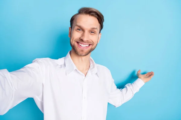 Fotografie šťastné pozitivní veselý mladý muž, aby selfie pozvat vás ruku izolované na pastelové modré barvy pozadí — Stock fotografie