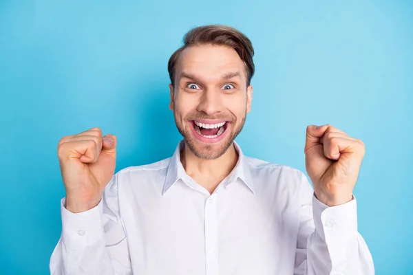 Fotografie šťastného ohromený mladý muž šílený nálada dosáhnout úspěchu vítěz izolované na pastelové modré barvy pozadí — Stock fotografie