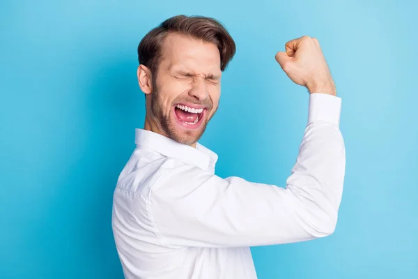 Profil boční fotografie funky šťastný mladý muž vítěz oslavit svaly izolované na pastelové modré barvy pozadí — Stock fotografie