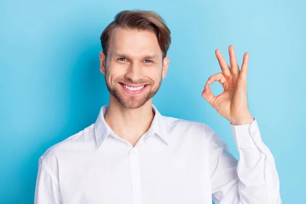 Foto von glücklichen positiven fröhlichen jungen Mann zeigen okay singen Lächeln isoliert auf pastellblauem Hintergrund — Stockfoto