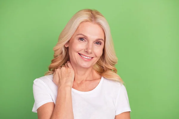 Zdjęcie flirt blondynka starszy pani dotyk szyi nosić biały t-shirt izolowane na pastelowy zielony kolor tła — Zdjęcie stockowe