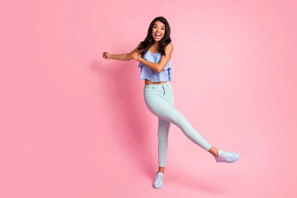 Full storlek foto av optimistiska brunett dam dans bära blå topp byxor sneakers isolerade på rosa färg bakgrund — Stockfoto