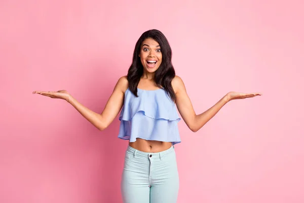 Foto di impressionato bruna signora tenere vuoto spazio indossare pantaloni blu superiore isolato su sfondo di colore rosa — Foto Stock