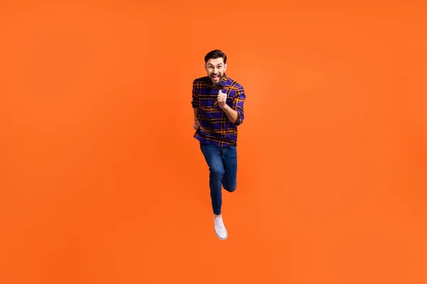 Foto de tamaño completo de loco hombre alegre saltando corriendo sonrisa toothy aislado en fondo de color naranja —  Fotos de Stock