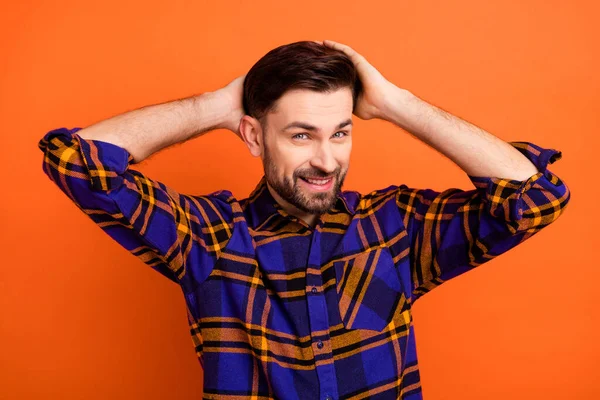 Foto pria muda bahagia Senyum positif tangan sentuhan rambut menikmati rambut baru ketombe diisolasi dengan latar belakang warna oranye — Stok Foto