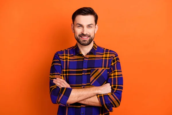 밝고 긍정적 인 미소를 짓고 있는 젊은 남자의 사진. 시원 한 접힌 손은 주황색 배경에 고립된 평범 한 셔츠를 입고 있습니다. — 스톡 사진