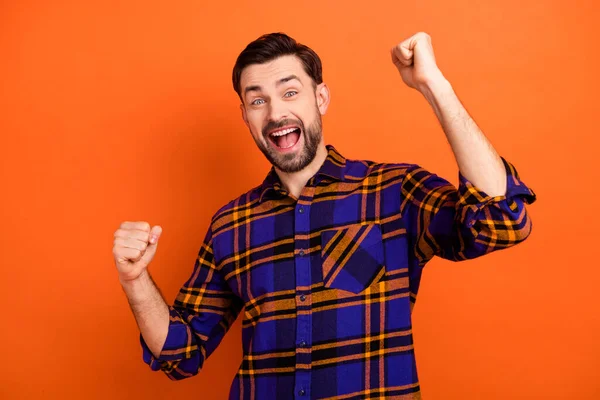 Foto di giovane uomo allegro felice sorriso positivo celebrare vincere vittoria fortunato lotteria pugni mani isolate su sfondo di colore arancione — Foto Stock