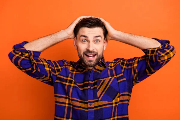 Photo de jeune homme excité heureux sourire mains toucher la tête étonné choqué surpris nouvelles vente isolé sur fond de couleur orange — Photo