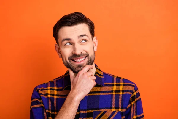 Foto de jovem alegre homem feliz sorriso positivo mão toque queixo sonho acho que olhar espaço vazio isolado sobre cor laranja fundo — Fotografia de Stock