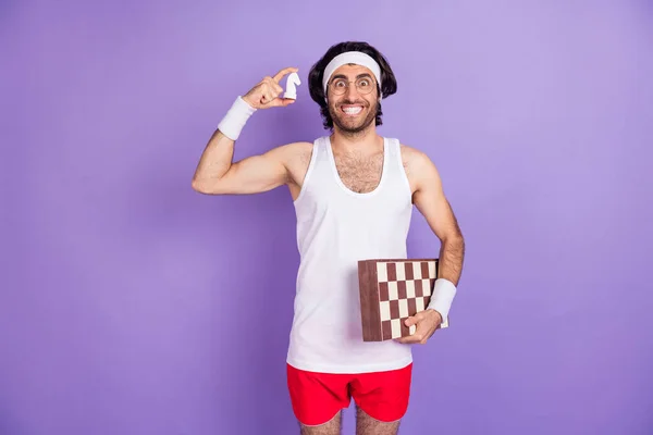 Foto de jovem alegre homem engraçado funky alegre em óculos segurar xadrez e xadrez figura isolada no fundo cor violeta — Fotografia de Stock