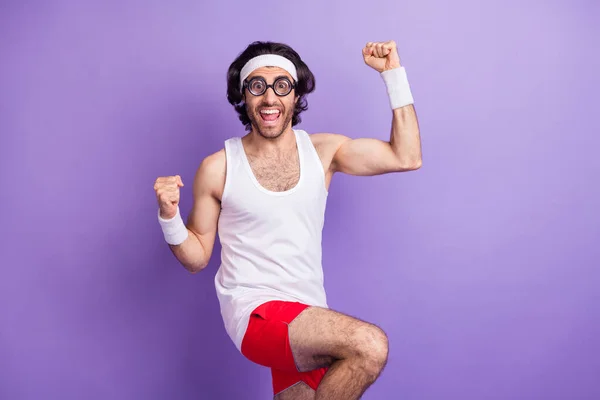 Photo of young happy cheerful excited man in glasses raise fist in victory success triumph isolated on violet color background — Zdjęcie stockowe