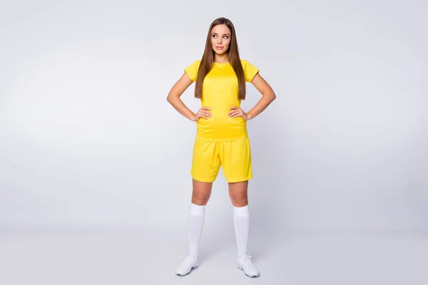 Full body photo of cool lady skilled player soccer women team look side empty space wear yellow football uniform yellow t-shirt shorts socks shoes isolated white color background — Zdjęcie stockowe