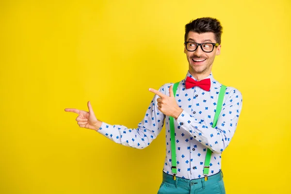 Photo of young cheerful man look point finger empty space ad promo advice choice isolated over yellow color background — Stockfoto