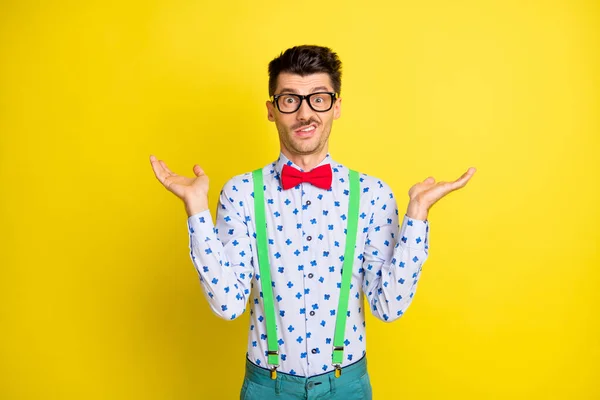 Photo of young man shrug shoulders uncertain clueless no answer isolated over yellow color background — Stockfoto