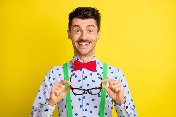 Foto de jovem animado homem feliz sorriso positivo surpreso segurar as mãos óculos isolados sobre fundo de cor amarela — Fotografia de Stock