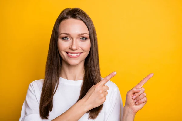 Photo portrait of woman pointing two fingers at blank space isolated on vivid yellow colored background — Stock Photo, Image