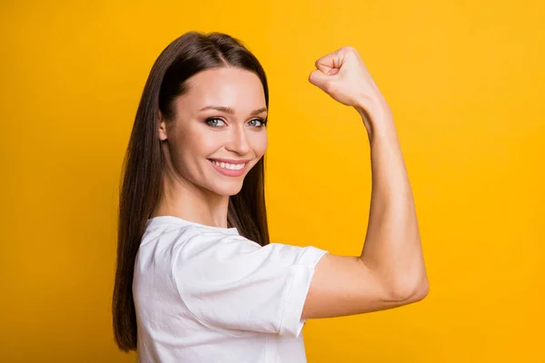 Photo portrait of powerful woman flexing biceps isolated on vivid yellow colored background — Stock Photo, Image
