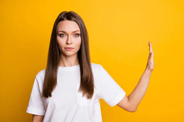 Фотопортрет молодої серйозної дівчини, що демонструє заборонний жест з долонею ізольовано на яскраво-жовтому кольоровому фоні з копійкою — стокове фото