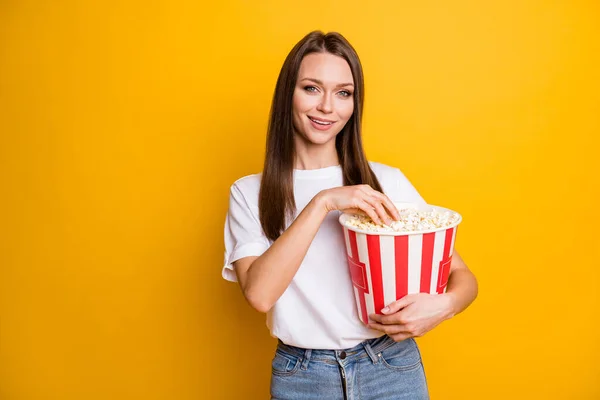フォトポートレートの美しいです女の子とともに茶色まっすぐ髪食べるポップコーンで映画館隔離された鮮やかな黄色の背景 — ストック写真