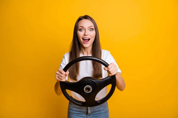 Foto portret van verbaasd verrast brunette meisje houden stuurwiel oefenen rijden geïsoleerde heldere gele kleur achtergrond — Stockfoto