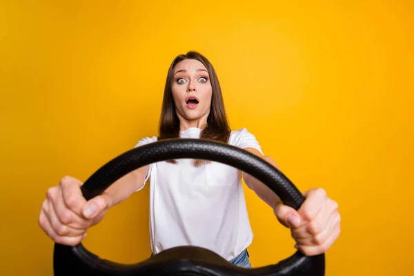 Foto retrato de chica morena nerviosa asustada practicando la conducción primera vez aislada sobre un fondo de color amarillo vibrante —  Fotos de Stock