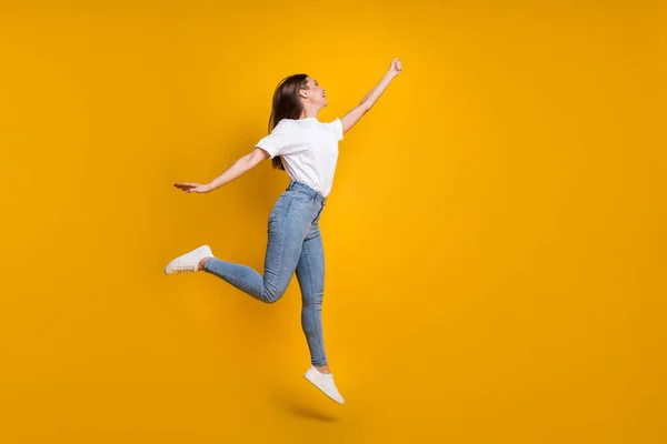 Foto penuh ukuran tubuh gadis riang dengan melompat rambut panjang tangan tetap up bayangkan terisolasi pada warna kuning cerah latar belakang — Stok Foto