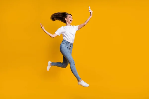Full length body size φωτογραφία της όμορφης γυναίκας που παίρνει selfie ρίχνοντας τα μαλλιά άλμα επάνω απομονωμένη σε φωτεινό κίτρινο χρώμα φόντο — Φωτογραφία Αρχείου