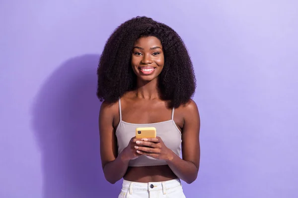 Portret van aantrekkelijke vrolijke meisje met behulp van apparaat browsen media commentaar chatten geïsoleerd over violet paarse kleur achtergrond — Stockfoto