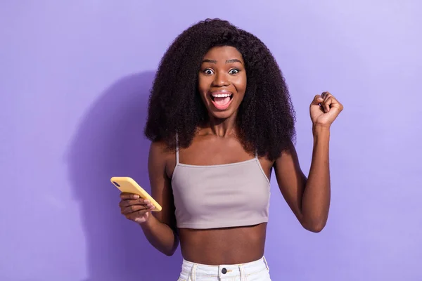 Portret van aantrekkelijke gelukkige verbaasd vrolijk meisje met behulp van apparaat browsen media plezier geïsoleerd over violet paarse kleur achtergrond — Stockfoto
