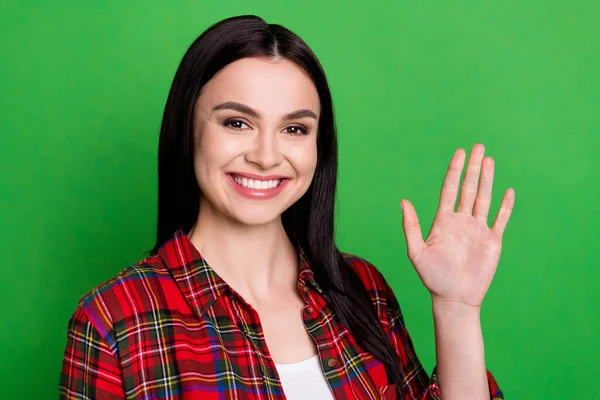 Foto di bruna impressionato giovane donna onda mano indossare camicia rossa isolata su sfondo di colore verde — Foto Stock