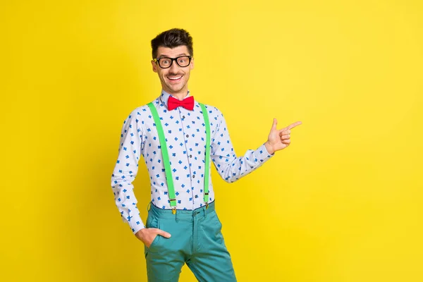 Foto de jovem alegre homem feliz sorriso positivo indicam dedos espaço vazio anúncio promo escolha isolado sobre cor amarela fundo — Fotografia de Stock
