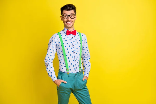 Portret van een aantrekkelijke vrolijke man met print shirt hand in hand in zakken geïsoleerd over fel gele kleur achtergrond — Stockfoto