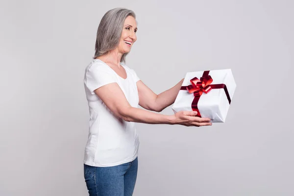Profil tarafı fotoğrafı mutlu mutlu bir gülümseme hediye paketi partisini gri arkaplan üzerine izole et — Stok fotoğraf