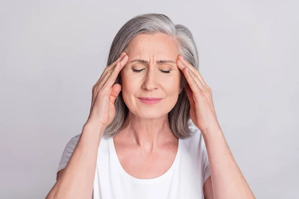 Фото рук літньої жінки дотик до голови біль страждає від хвороби мігрень, хворих ізольовано на сірому кольоровому фоні — стокове фото