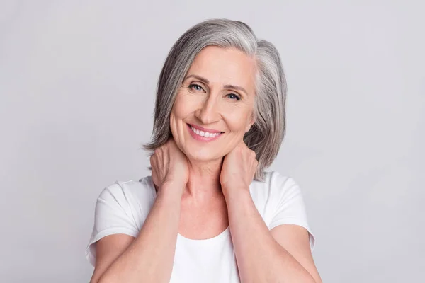 Foto de adorable señora madura dulce usar ropa blanca brazos cuello sonriendo aislado color gris fondo — Foto de Stock