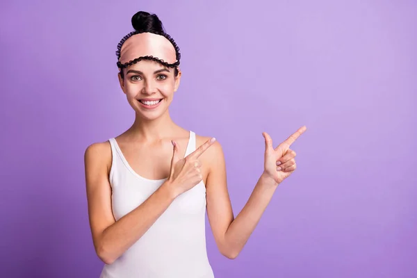 Foto ritratto di donna in maschera addormentata sorridente mostrando spazio vuoto consigliando sorridente isolato su sfondo di colore viola pastello — Foto Stock