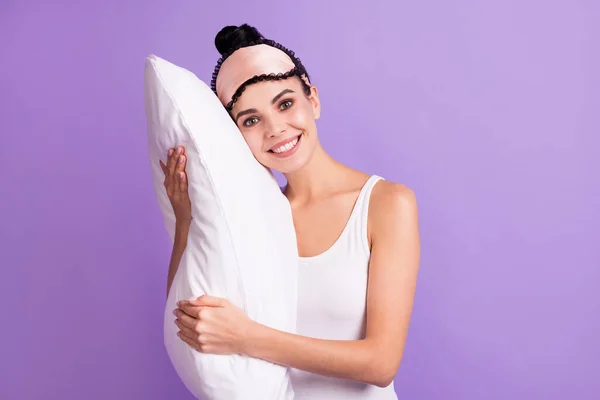 Photo of young beautiful positive smiling girl hug embrace pillow wear pajamas eye mask isolated on purple color background — Stock Photo, Image