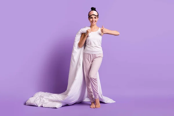 Tamanho total do corpo foto de menina mantendo cobertor vestindo pijama mostrando sinal de polegar para cima isolado pastel cor violeta fundo — Fotografia de Stock
