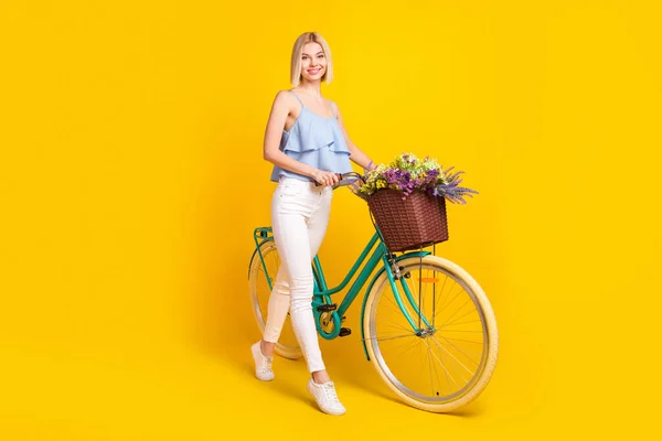 Foto de perfil de corpo inteiro de cabelo loiro positivo senhora passeio de bicicleta usar calças superiores isoladas no fundo amarelo — Fotografia de Stock