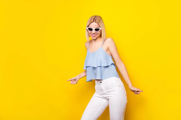 Foto av positiva söta blond kort hår dam dans bära glasögon blå topp isolerad på gul färg bakgrund — Stockfoto