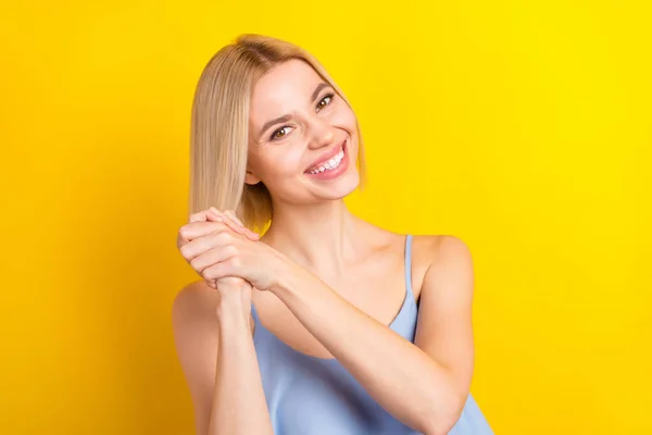 Zdjęcie pozytywne blondynka krótkie włosy pani trzymać za ręce nosić niebieski top odizolowany na żółtym tle — Zdjęcie stockowe