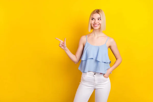 肯定的なクールなブロンドの短い髪の女性のポイントの写真空のスペースは、黄色の色の背景に隔離された青の上を着用見える — ストック写真