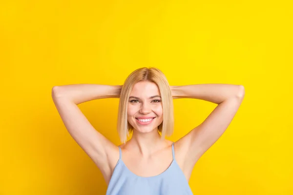 Foto van positieve leuke blonde korte haar dame handen hoofd slijtage blauwe top geïsoleerd op levendige gele kleur achtergrond — Stockfoto