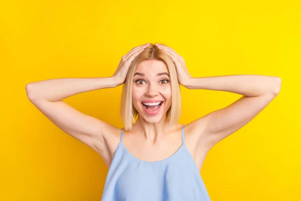 Foto rambut pendek wanita pirang yang terkesan memakai topi biru terisolasi pada latar belakang warna kuning cerah — Stok Foto