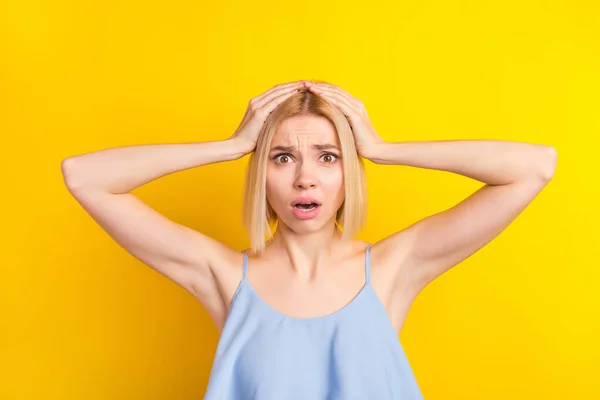 Foto van trieste onder de indruk blond kort haar dame handen hoofd dragen blauwe top geïsoleerd op levendige gele kleur achtergrond — Stockfoto